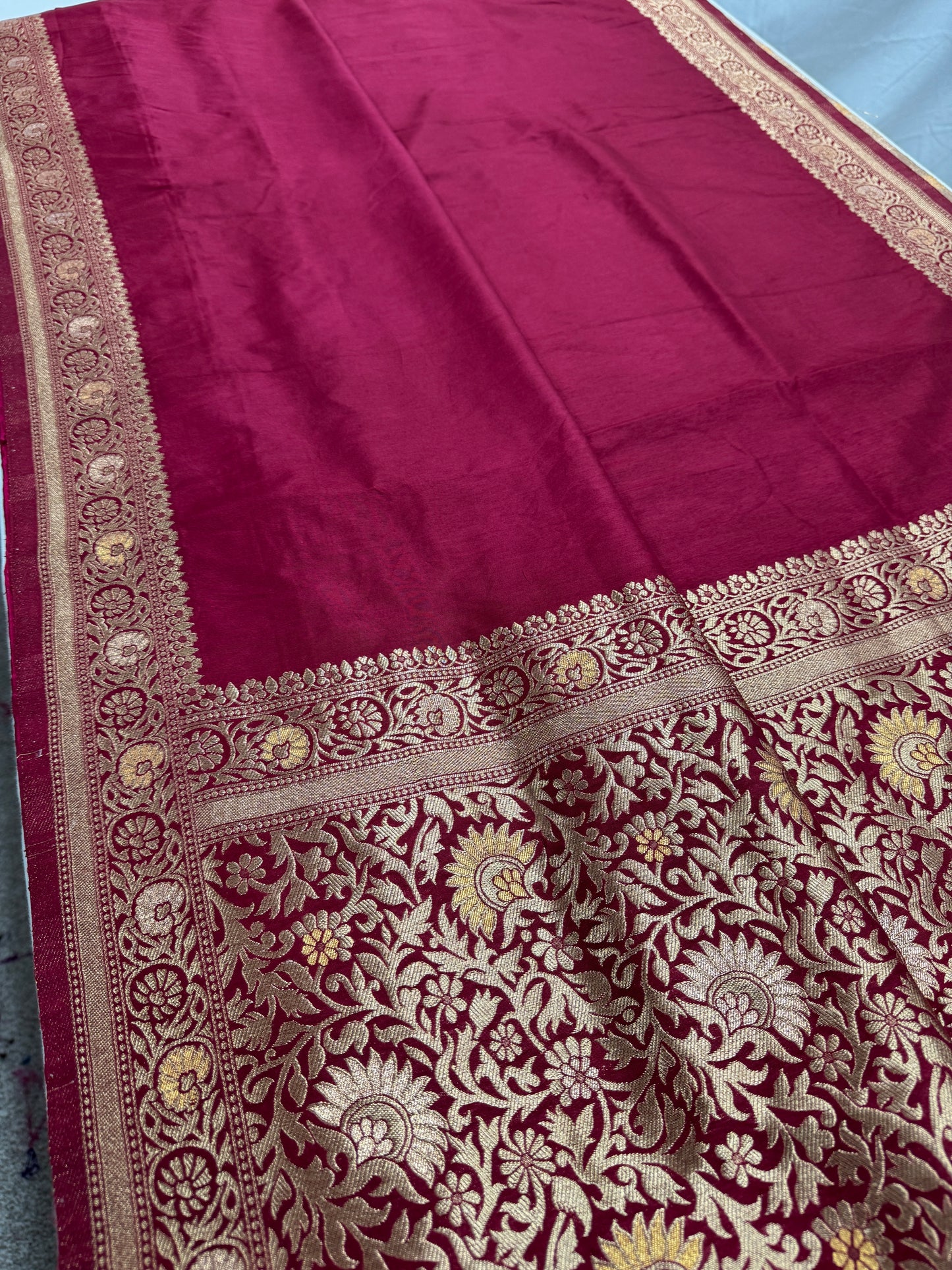 Maroon saree with intricate gold and white patterns