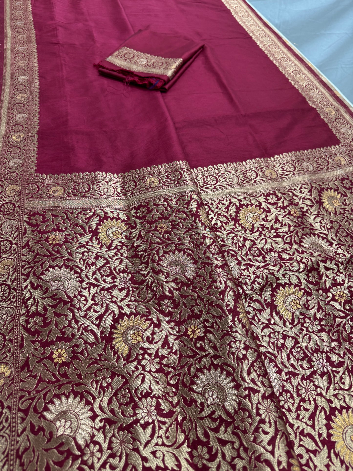 Close-up of a maroon fabric with intricate gold patterns