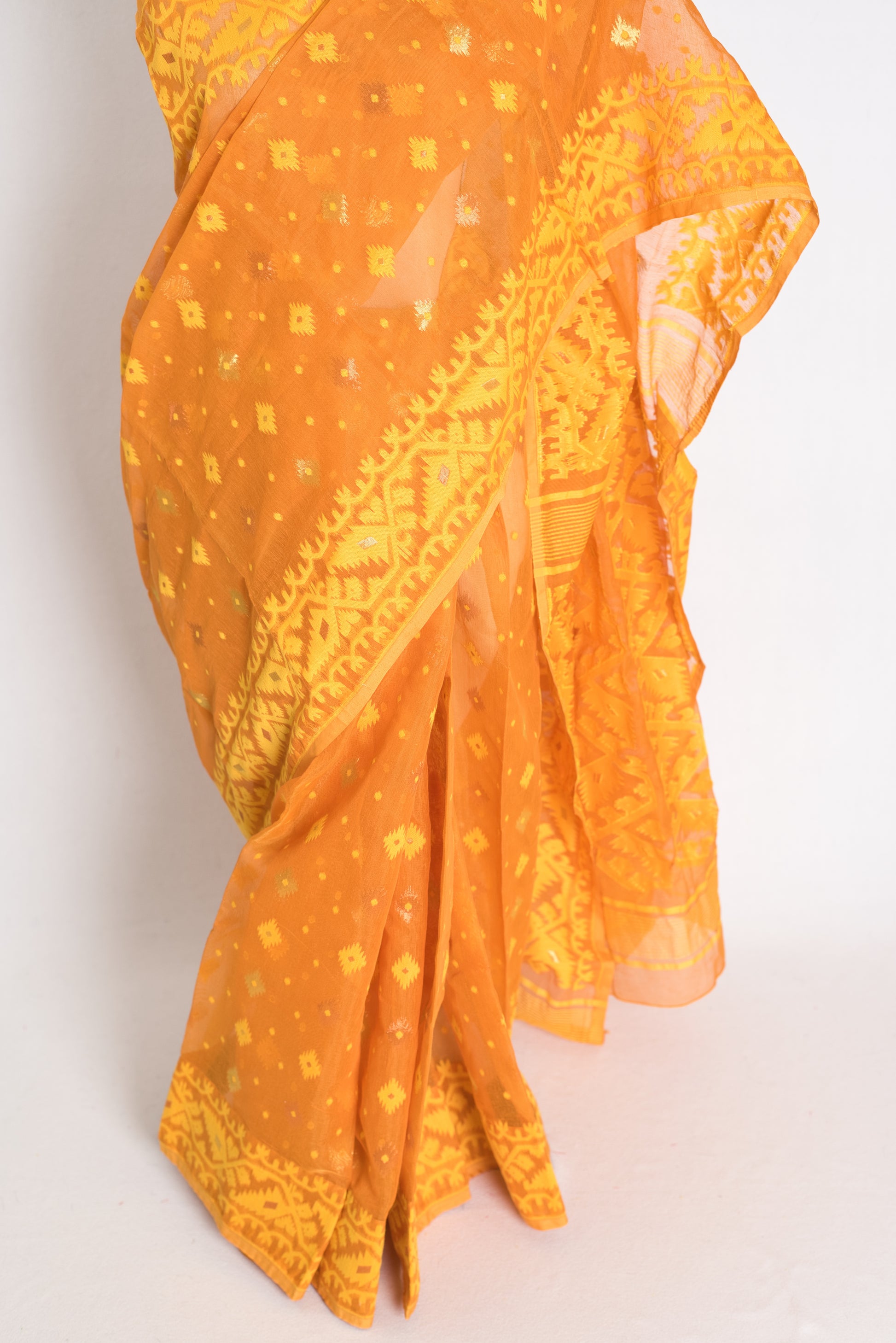 An earthy brown and yellow blended Jamdani saree in soft cotton, featuring traditional Bengali hand-loomed motifs and a sophisticated matte finish.