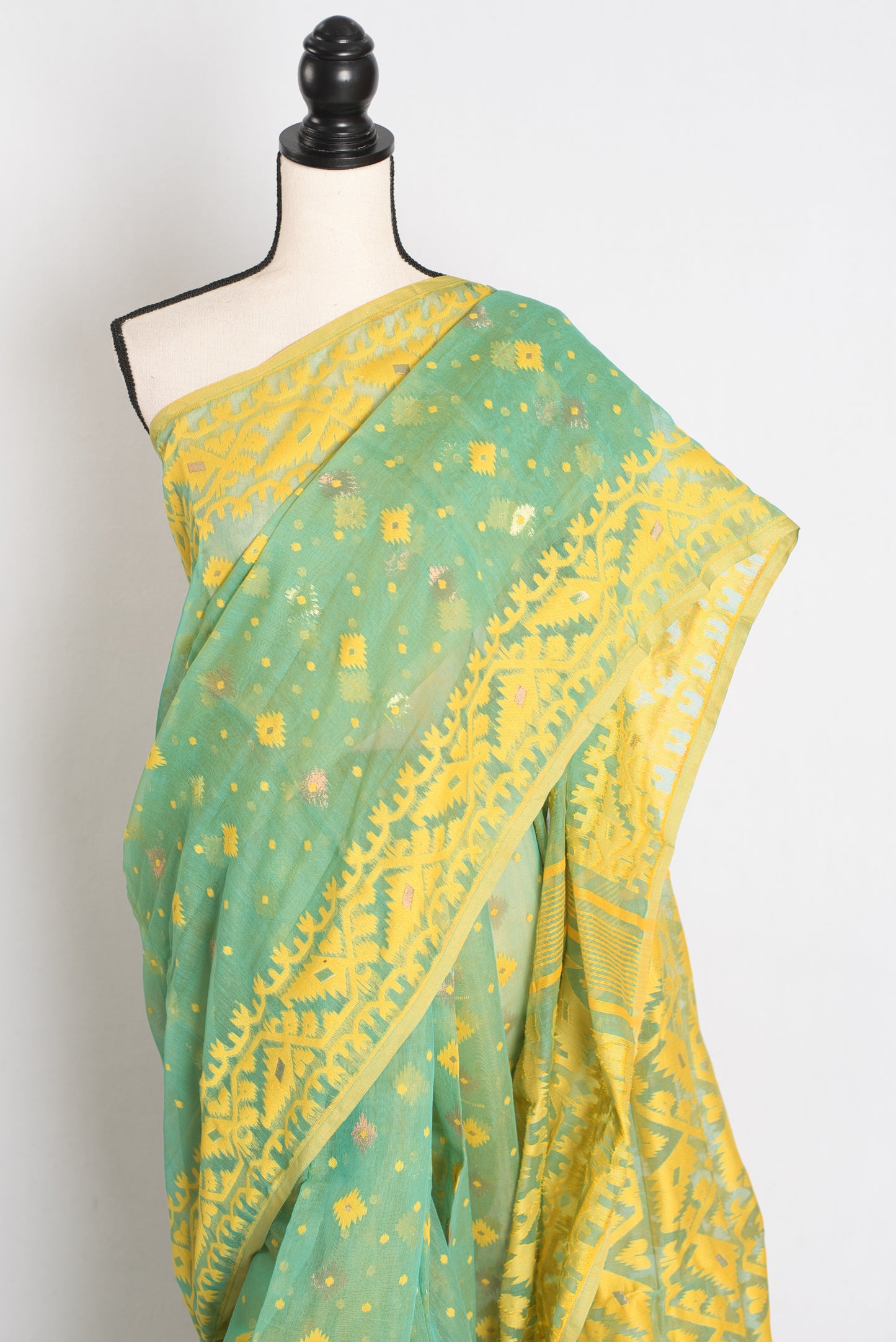 A refreshing sea green and yellow blended Jamdani saree in soft cotton, featuring traditional Bengali hand-loomed motifs and a delicate drape.