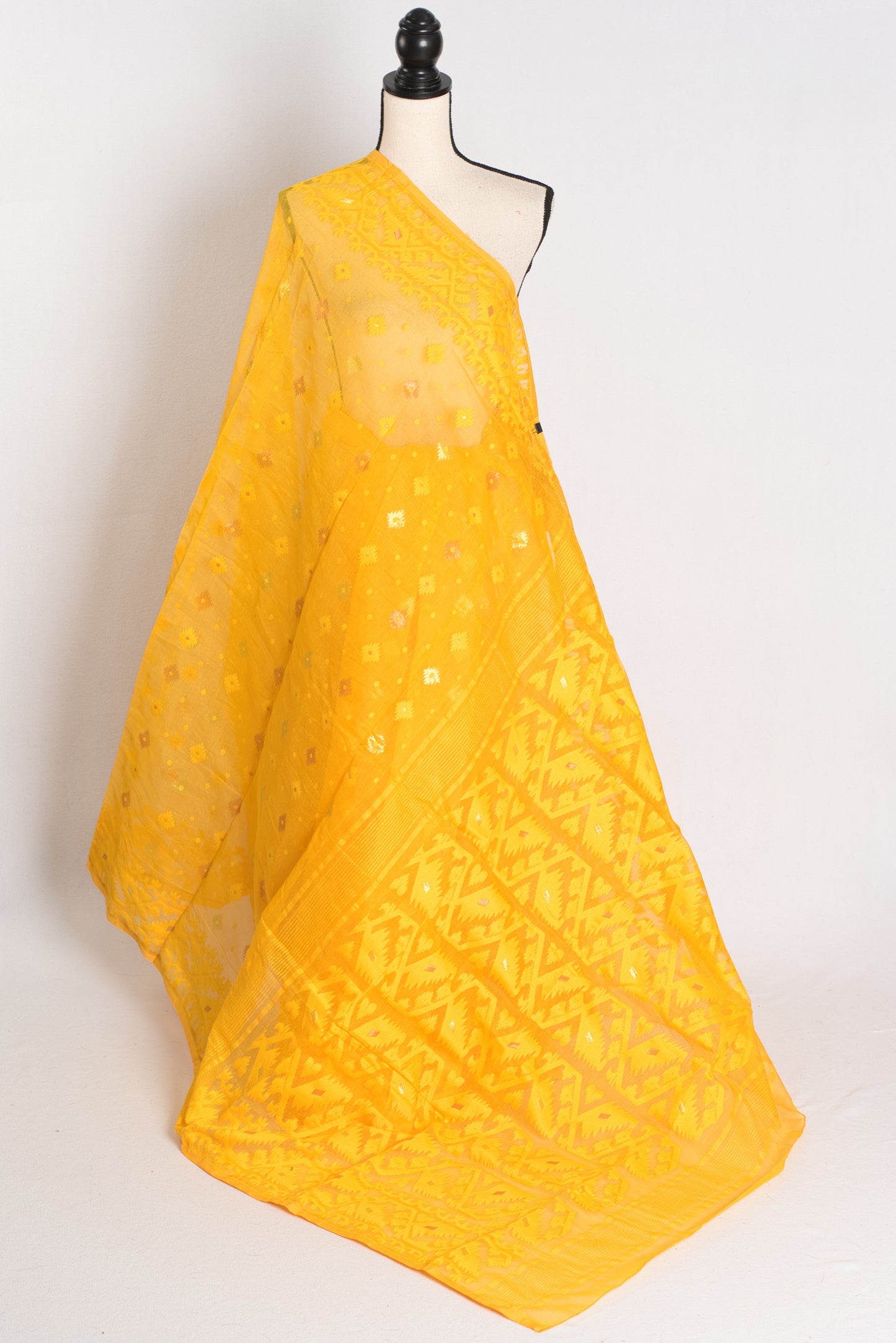 A vibrant deep yellow Bengali Jamdani saree crafted from a soft cotton blend, featuring traditional hand-loomed patterns perfect for festive occasions.