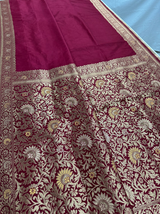 Maroon fabric with intricate gold and white floral patterns