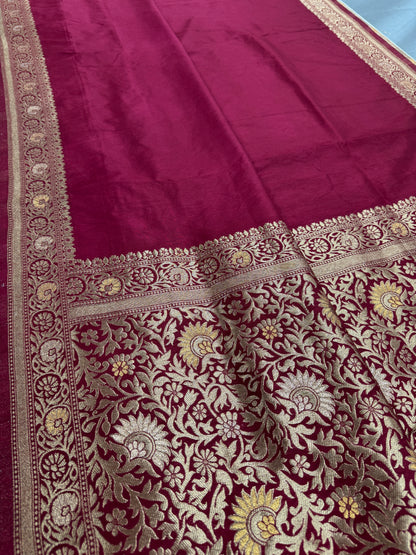 Maroon fabric with intricate gold and white embroidery