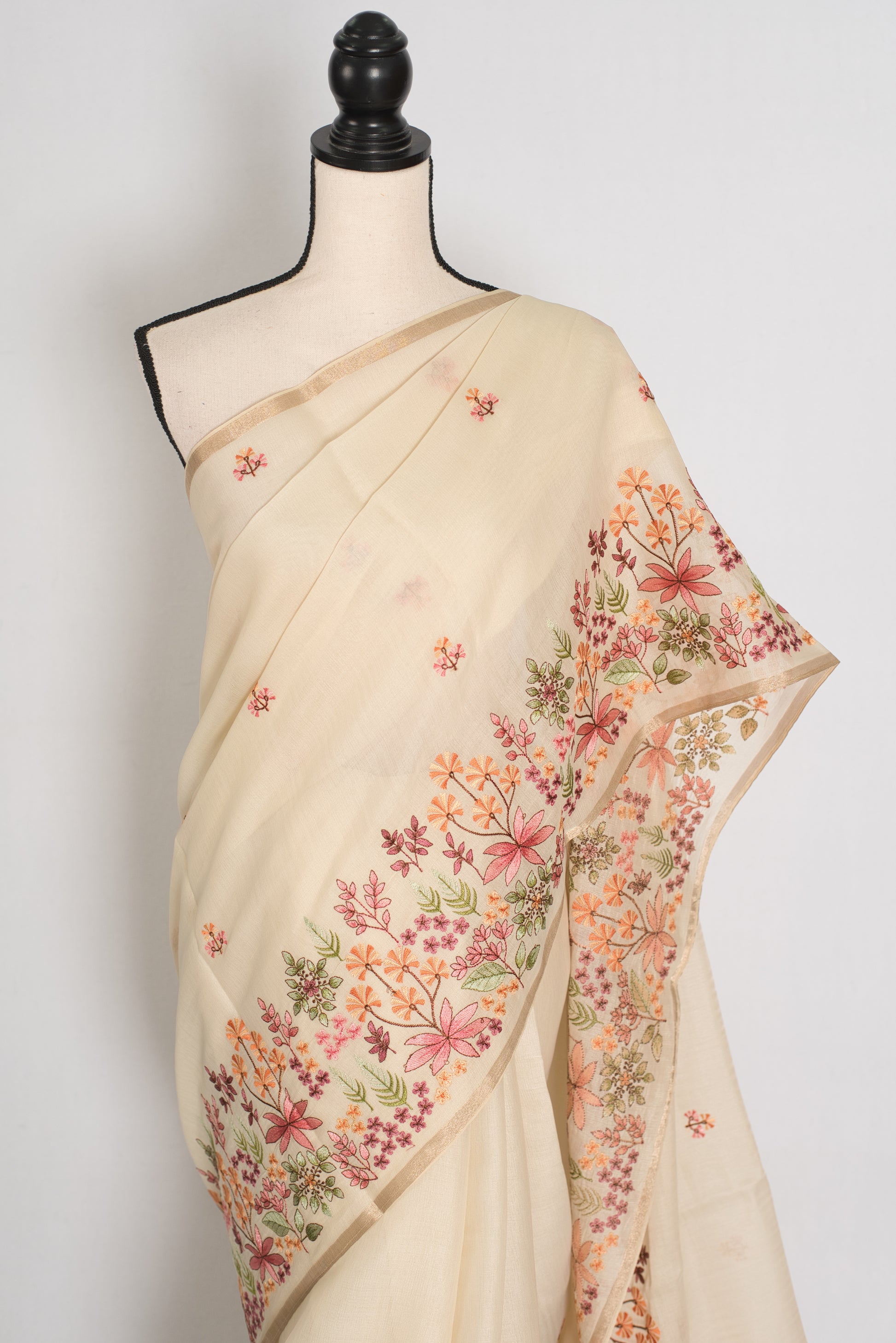 Beige saree with floral embroidery on a mannequin against a white background
