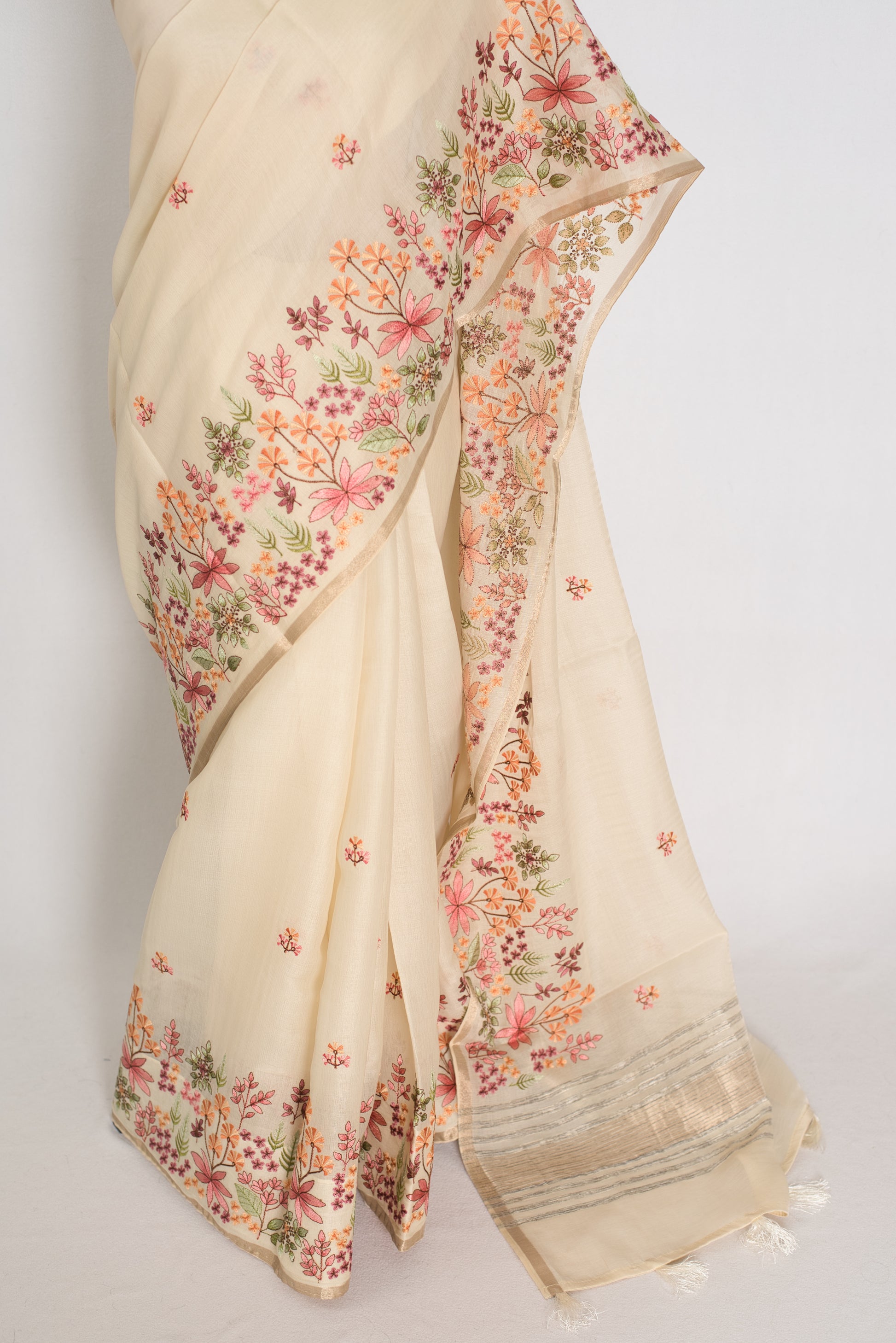 Beige saree with floral patterns on a plain background