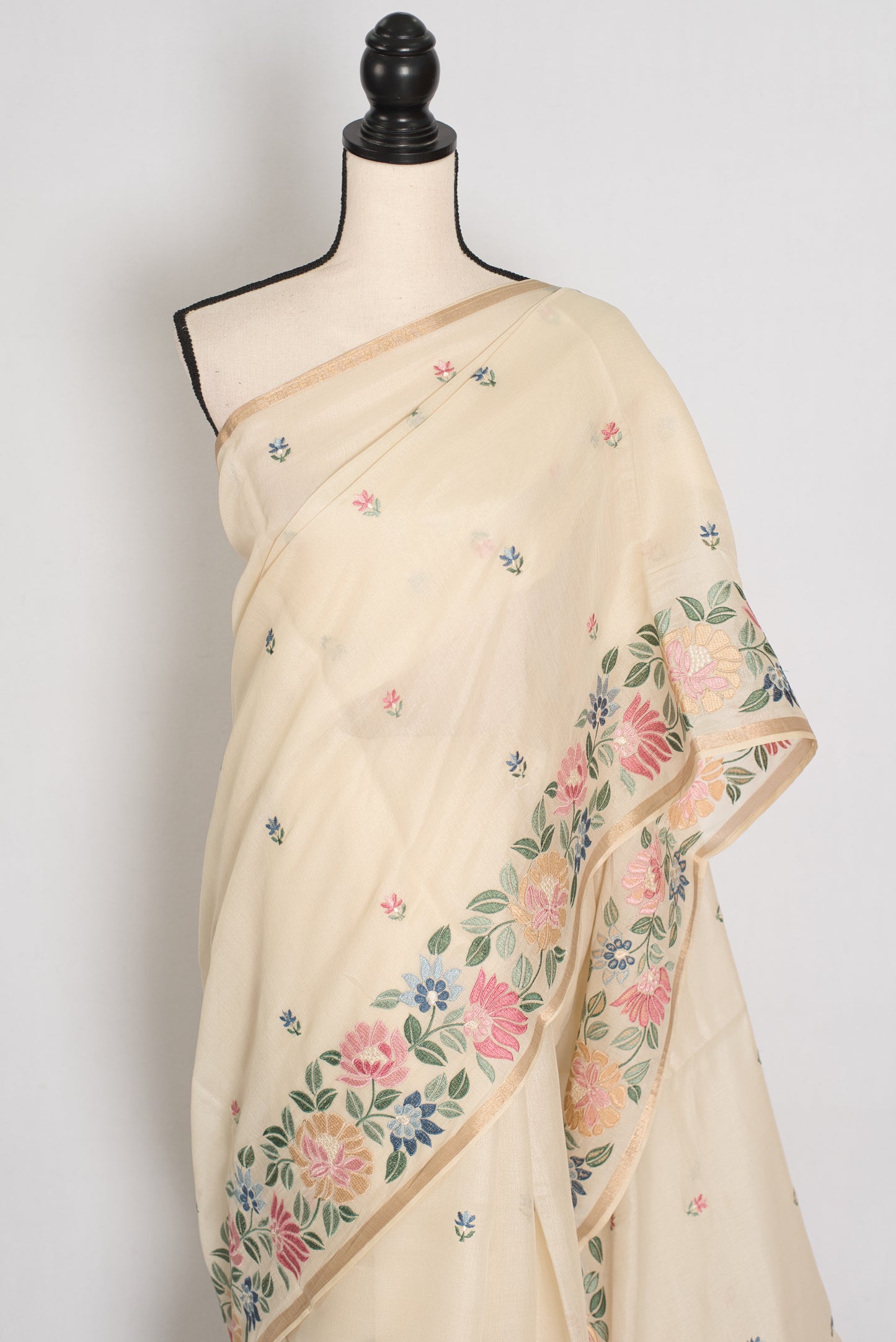 Beige saree with floral embroidery on a mannequin against a white background
