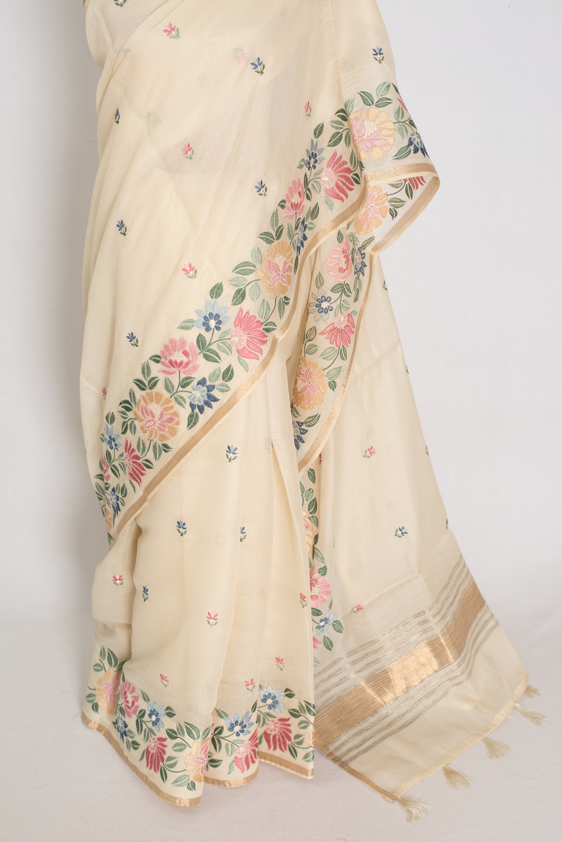 Beige saree with floral patterns on a plain background