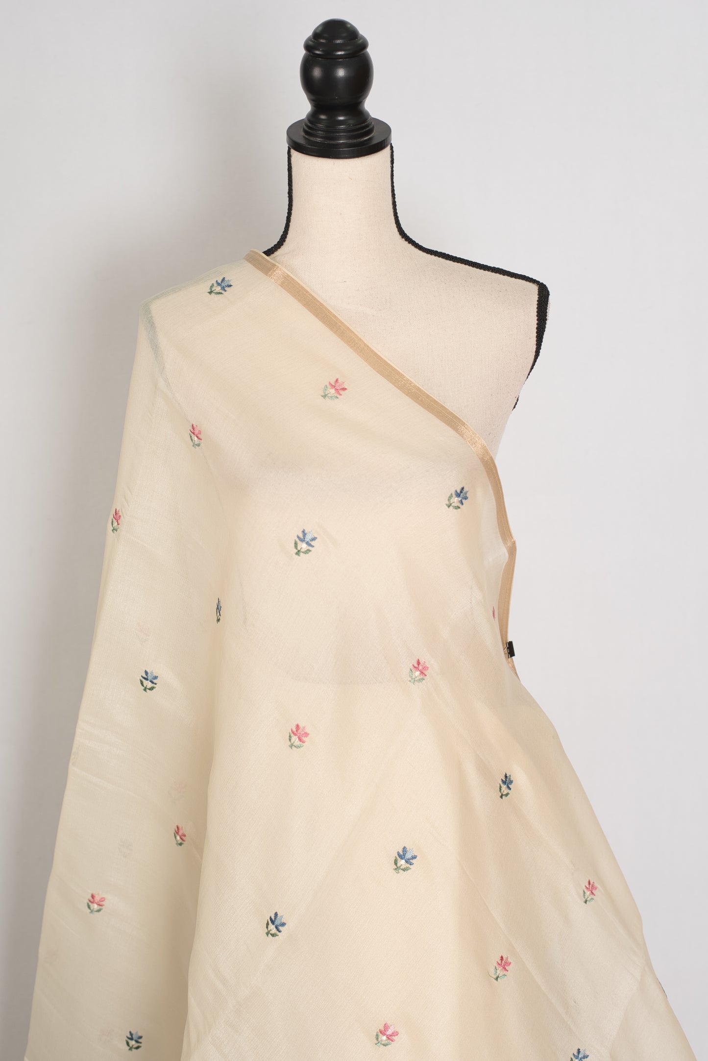 Beige saree with floral embroidery on a mannequin against a white background
