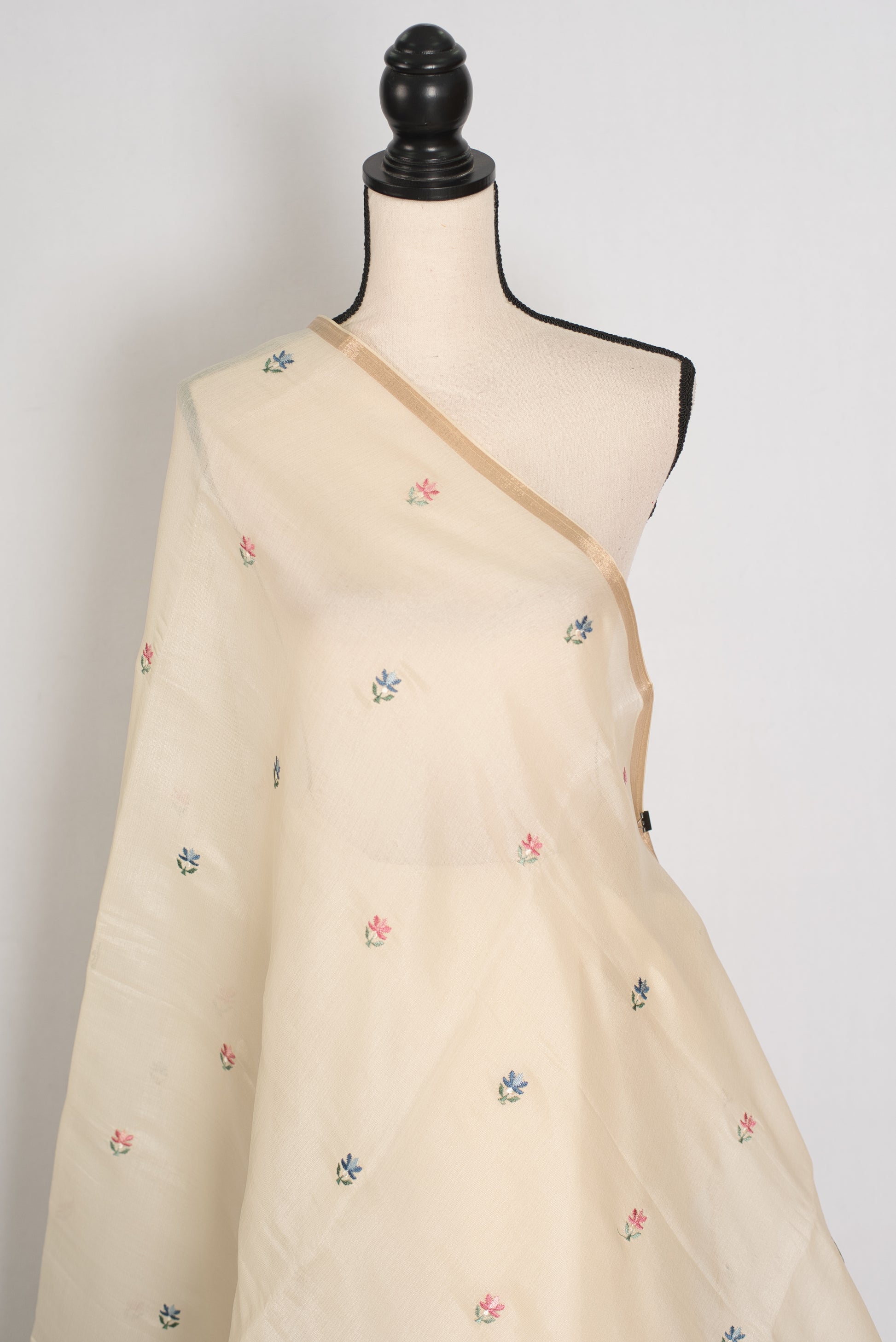 Beige saree with floral embroidery on a mannequin against a white background