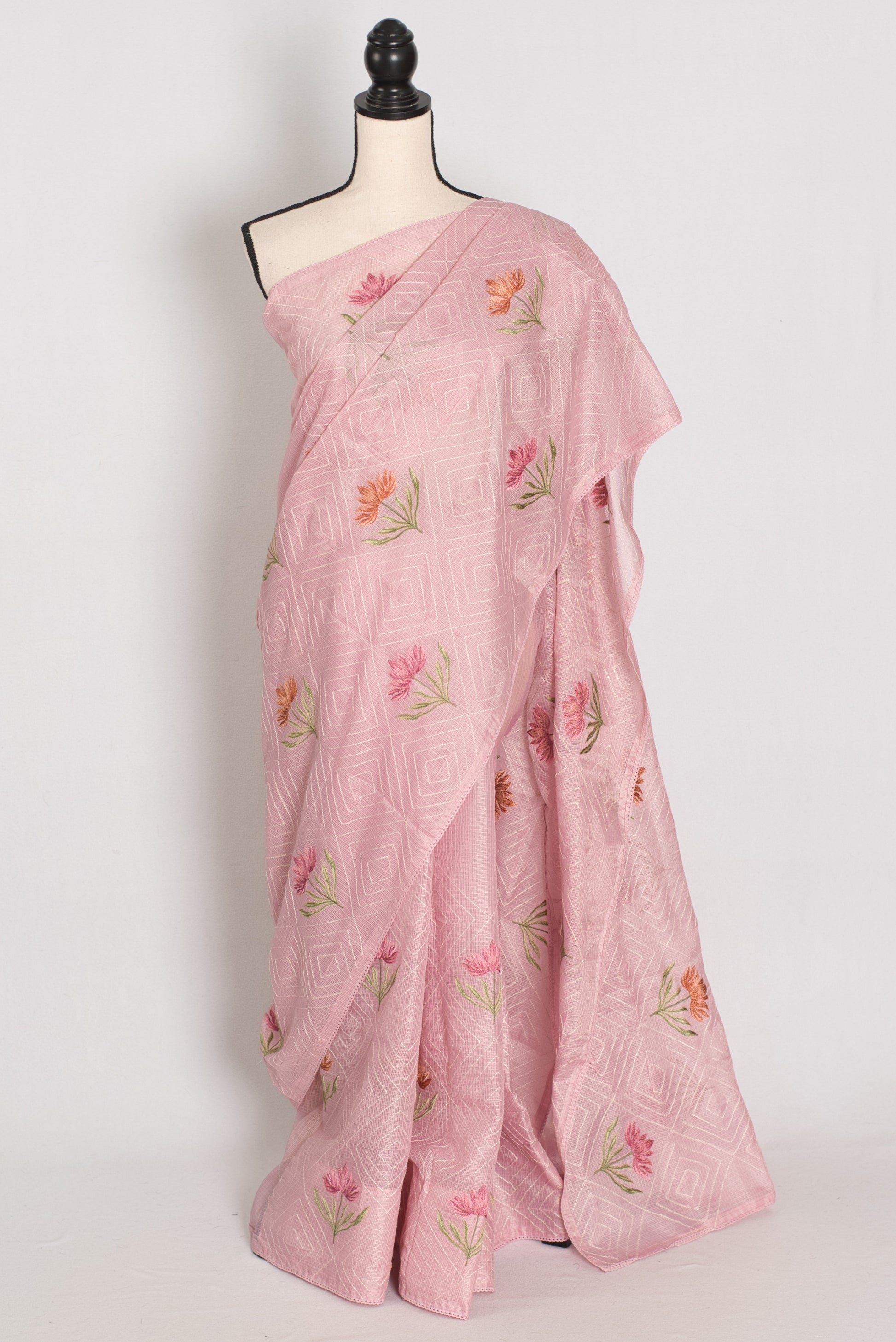 Pink saree with floral patterns on a mannequin against a white background