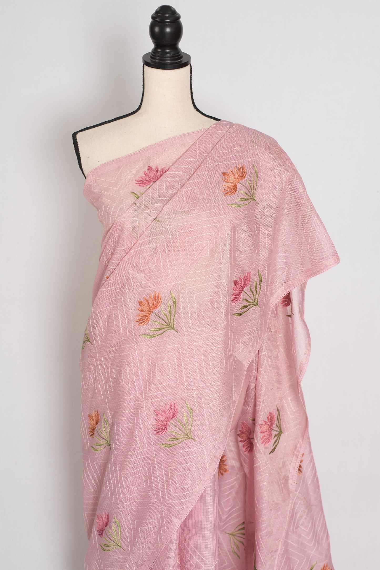 Pink saree with floral embroidery on a mannequin against a white background