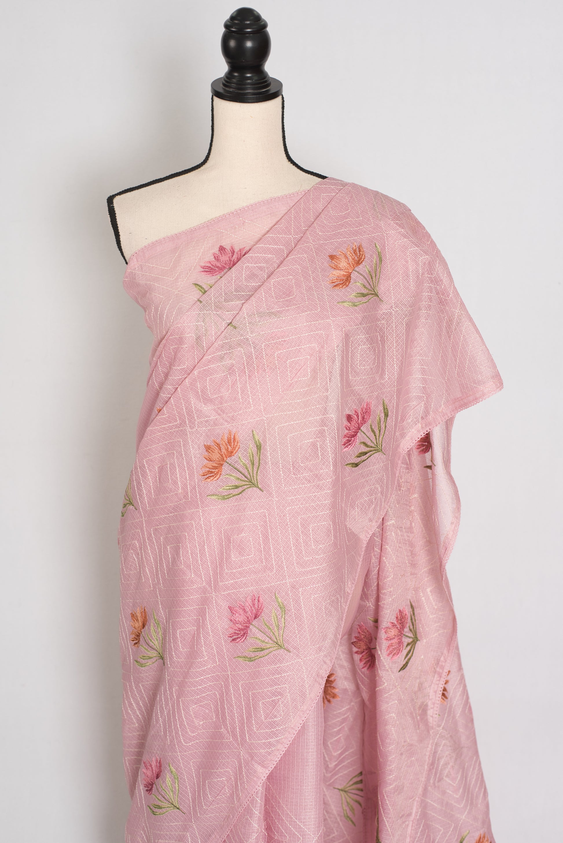 Pink saree with floral embroidery on a mannequin against a white background