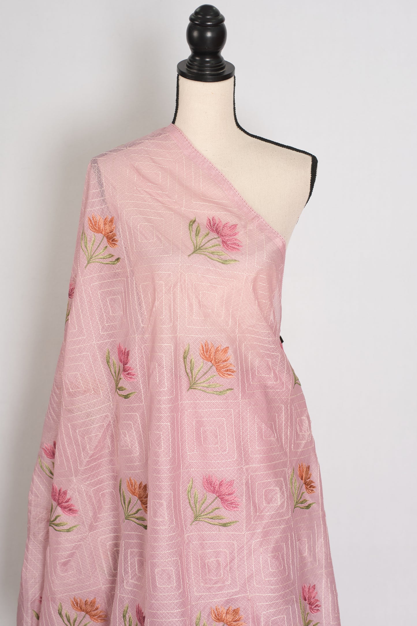 Pink saree with floral embroidery on a mannequin against a white background