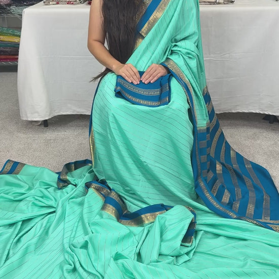 Video of Aqua blue Mysore crepe silk saree with vertical gold zari stripes and a contrast teal-blue border.