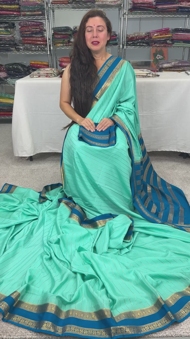 Video of Aqua blue Mysore crepe silk saree with vertical gold zari stripes and a contrast teal-blue border.