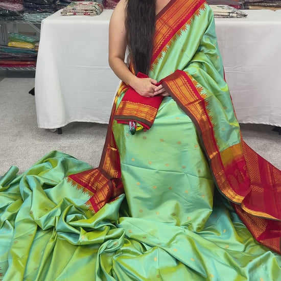 Sea green pure Gadwal silk saree with a rich red and gold zari border.
